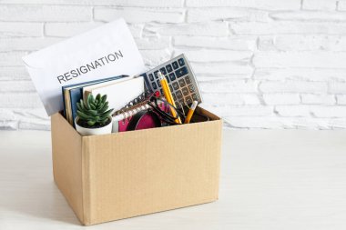 Masasında ofis malzemeleri olan karton bir kutu. İstihdam ve istifa kavramının reddedilmesi. İflas ve ekonomik kriz.