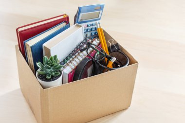 Masasında ofis malzemeleri olan karton bir kutu. İstihdam ve istifa kavramının reddedilmesi. İflas ve ekonomik kriz.