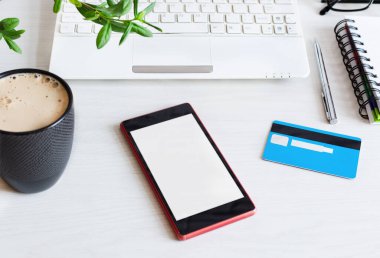Akıllı telefon boş ekran ve beyaz ahşap ofis masasında kredi kartı. İnternetten alışveriş konsepti. Tasarımın için bir model.