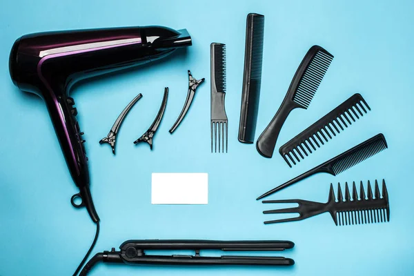 combs and hairdresser tools on blue background top view