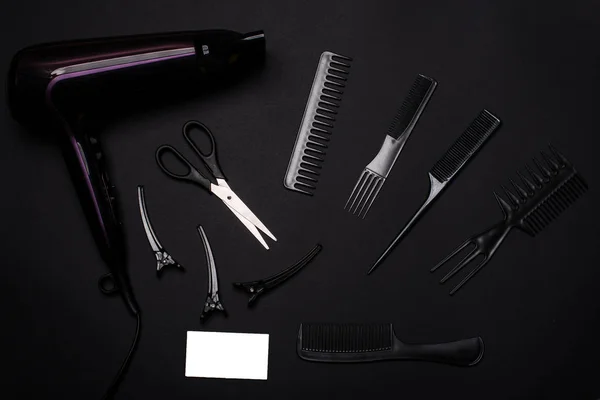 combs and hairdresser tools on black background top view