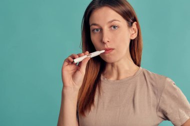 Elektronik Sigara Teknolojisi. Tütün Iqos sistemi. Isıtma yastığıyla elektrikli sigara içen bir kızın yakın çekimi. tütün ısıtma sistemi.