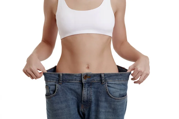 Perfect, slim, young body of a girl in white underwear. Weight loss and healthy eating. A woman in jeans of large size. The problem of obesity. Plastic surgery. — Stock Photo, Image