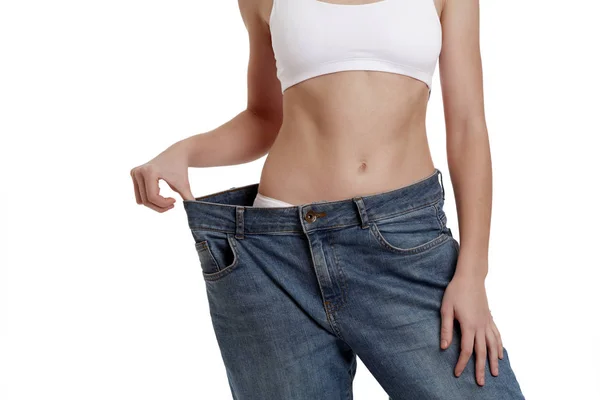 Perfeito, magro, corpo jovem de uma menina de roupa interior branca. Perda de peso e alimentação saudável. Uma mulher de jeans de tamanho grande. O problema da obesidade. Cirurgia plástica . — Fotografia de Stock