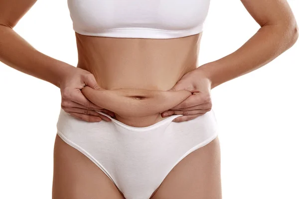 Beyaz iç çamaşırlı genç bir kızın mükemmel, ince, genç vücudu. Kilo kaybı ve sağlıklı beslenme. Göbeğinde yağ gösteren bir kız. Obezite sorunu. Estetik ameliyat.