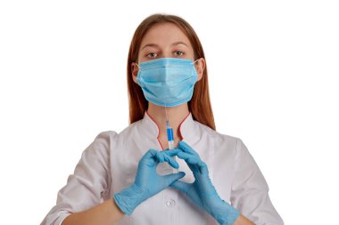 Beyaz önlüklü bir kadın doktorun yakın plan fotoğrafı. Doktor elinde ilaç olan bir şırınga tutuyor. Beyaz arka planda beyaz önlüklü bir doktor..