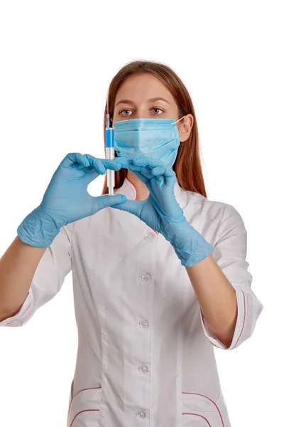 Photo rapprochée d'une femme médecin vêtue d'un manteau blanc. Le médecin tient une seringue avec des médicaments dans les mains. Docteur en manteau blanc sur fond blanc . — Photo