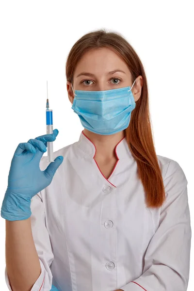 Photo rapprochée d'une femme médecin vêtue d'un manteau blanc. Le médecin tient une seringue avec des médicaments dans les mains. Docteur en manteau blanc sur fond blanc . — Photo