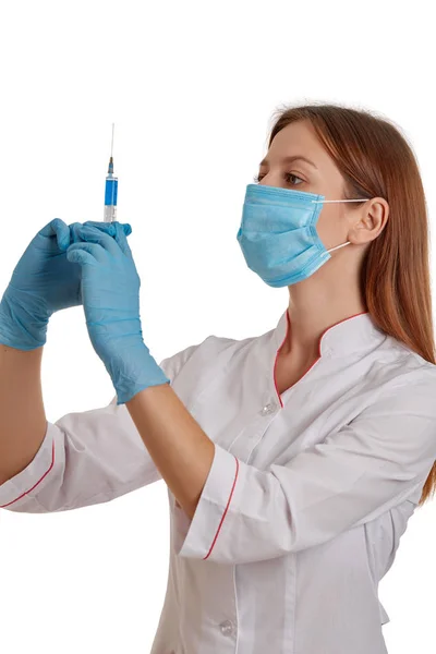 Photo rapprochée d'une femme médecin vêtue d'un manteau blanc. Le médecin tient une seringue avec des médicaments dans les mains. Docteur en manteau blanc sur fond blanc . — Photo