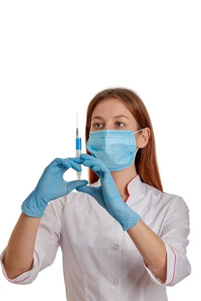 Beyaz önlüklü bir kadın doktorun yakın plan fotoğrafı. Doktor elinde ilaç olan bir şırınga tutuyor. Beyaz arka planda beyaz önlüklü bir doktor..