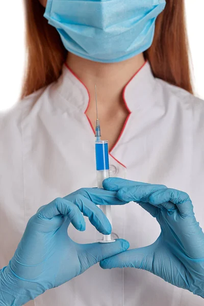 Beyaz önlüklü beyaz önlüklü doktor elinde ilaç olan bir şırınga tutuyor. Solunum maskeli bir hemşire kendini hızla yayılan yeni koronavirüsten korur. M konsepti — Stok fotoğraf