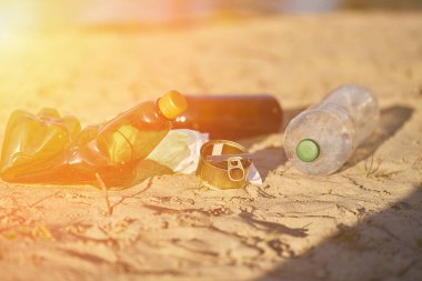 Plastik plaj şişelerinin kirliliği. Kullanılmış kirli şişe ve teneke kutular. Kirli kumsal. Ekolojik bir sorun. Çevre konsepti. Doğayı kurtar..