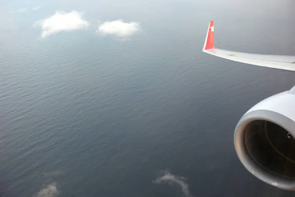 Utsikt över havet och molnen från ett flygplan-fönster — Stockfoto