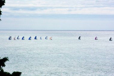 A group of sailboats sailing in the Black Sea in backlight