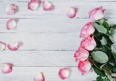 Kutlama çerçeve beyaz tahtalar üzerinde pembe Güllü.