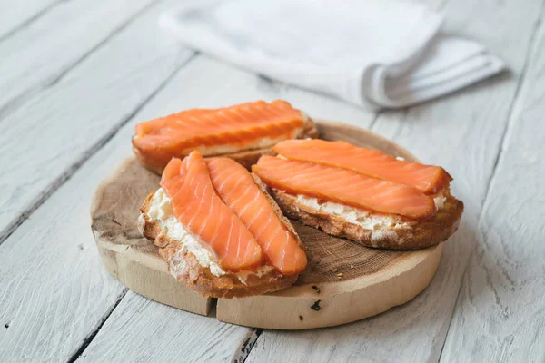 Сэндвичи с копченым лососем и сливочным сыром на белом дереве — стоковое фото