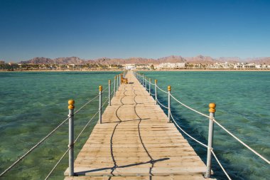 İskele şezlong şezlong içinde Kızıldeniz resort'ile. Kızıldeniz yaz tatili. Turkuaz su ile açık denizde görüntüleyin. Egzotik bir yerde deniz kıyı şeridi, yaz tatili