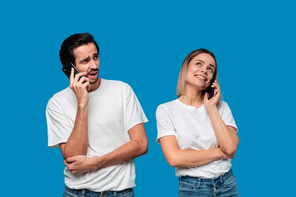 Blonde Frau und brünetter Mann in weißen T-Shirts und blauen Jeans telefonieren. — Stockfoto