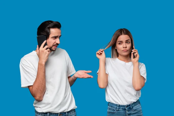 Blonde Frau und brünetter Mann in weißen T-Shirts und blauen Jeans telefonieren. — Stockfoto