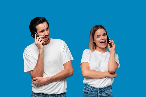 Blonde Frau und brünetter Mann in weißen T-Shirts und blauen Jeans telefonieren. — Stockfoto