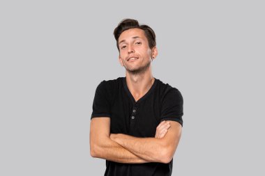 Siyah tişörtlü yakışıklı adam kameraya özenle bakıyor..