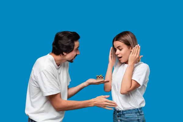 Novio dando regalo a su novia aislado sobre fondo azul . — Foto de Stock