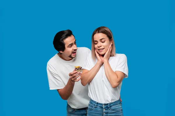 Novio dando regalo a su novia aislado sobre fondo azul . — Foto de Stock