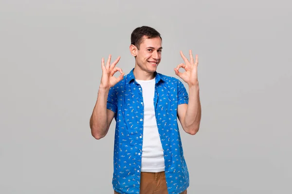 Handsome man showing OK sign with two hands smiling looking at the camera