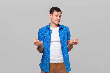 Üzgün adam, gri arka planda izole edilmiş bir şey alacak parası olmadığı için üzgün.