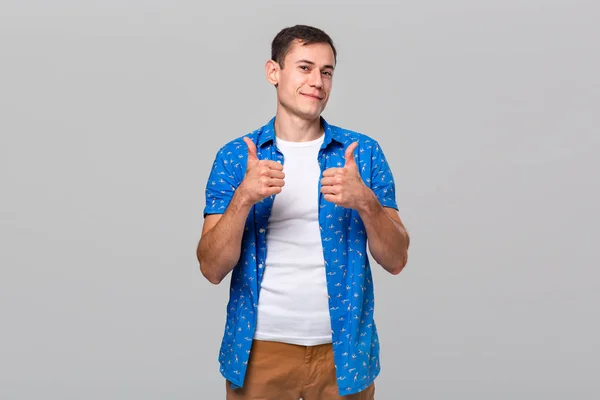 Sebevědomý usmívající se muž ukazující palec nahoru vyjadřující pozitivní hodnocení — Stock fotografie