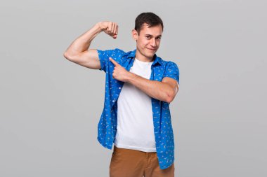 Yakışıklı adam kaslarını işaret ediyor..