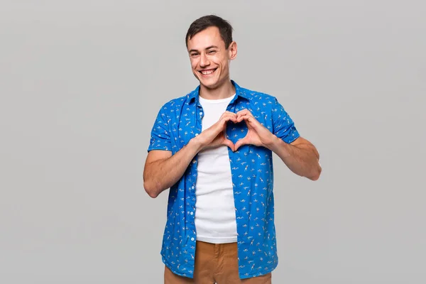 Homem feliz segurando dedos em forma de coração expressando amor e carinho — Fotografia de Stock