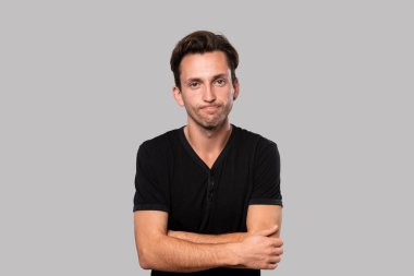 Gri arka planda ciddi bir sorunla karşı karşıya olan üzgün bir adam. Duygusal stres kavramı