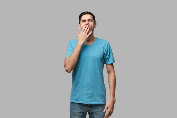 Joven moreno bostezando aislado sobre fondo gris. Estar cansado después de un largo día de trabajo . —  Fotos de Stock