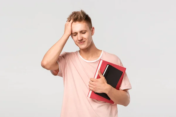 Stilig ung man med böcker och filer pekar med fingret mot huvudet — Stockfoto