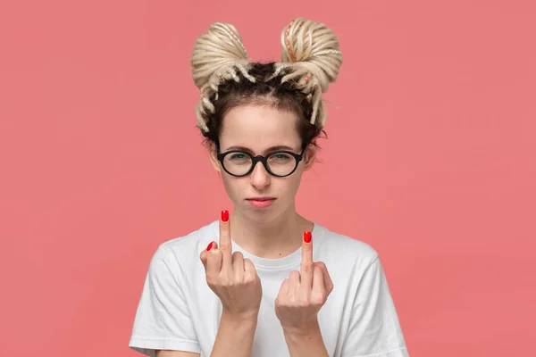 Girl with dreads in a white shirt and glasses showing middle finger to express fuck you gesture. — ストック写真