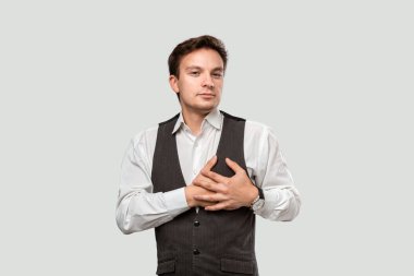 Young pretty man in a white shirt and grey vest making proposal of marriage