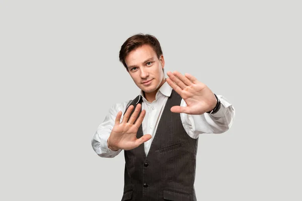 Hombre guapo Confindent en una camisa blanca y chaleco gris que expresa el gesto Stop — Foto de Stock