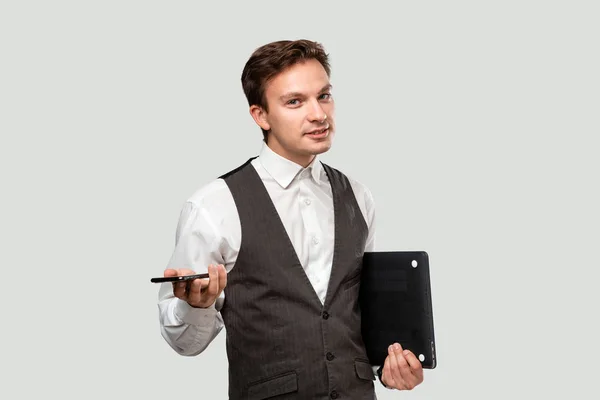 Exitoso empresario sosteniendo portátil aislado sobre fondo gris — Foto de Stock
