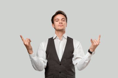 Confident man holding hands in a gesture of rock music fan to express emotion of success