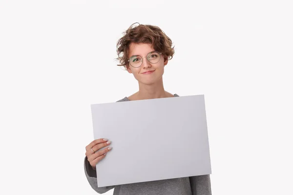 Smiling young woman with eyeglass holding empty blank paper board with copy space for text. — Stok fotoğraf