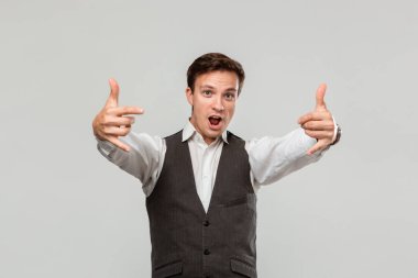 Confident man holding hands in a gesture of rock music fan to express emotion of success