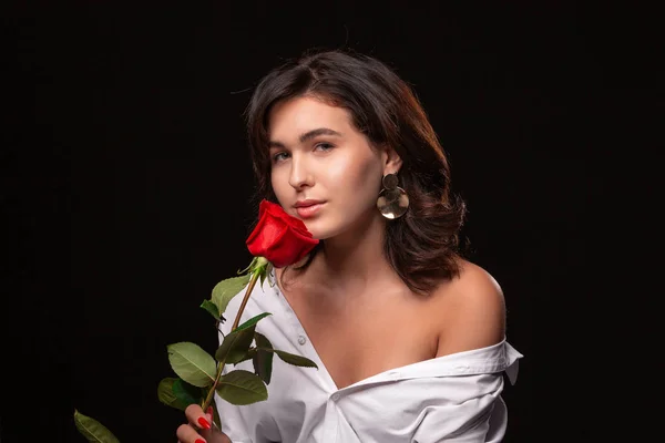 Красивая женщина с ярким макияжем позировать изолированы на черном фоне с красной розой . — стоковое фото