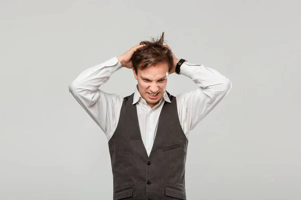 Hombre guapo con una camisa blanca y chaleco gris agarra la cabeza porque se enfrenta a algunos problemas . — Foto de Stock