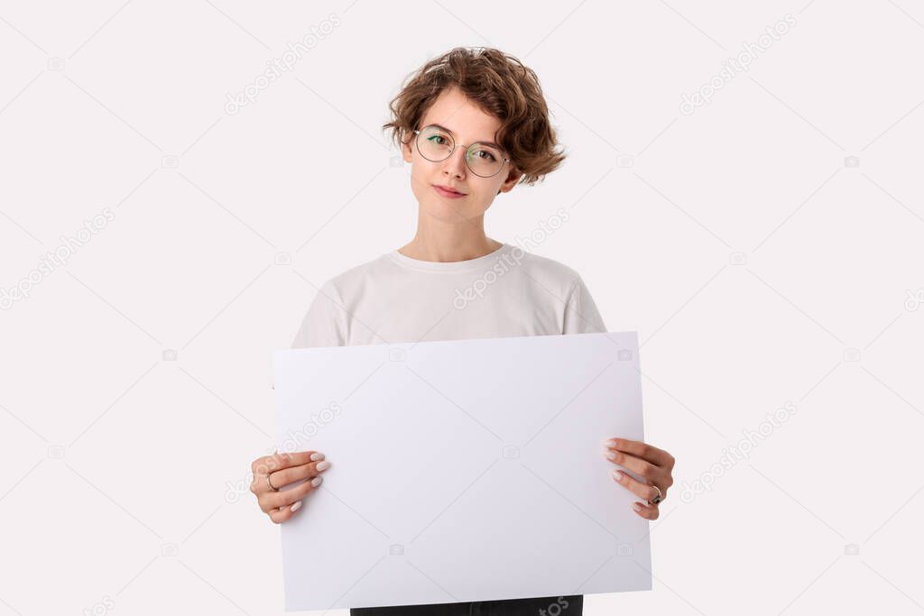 Pretty young woman with eyeglass holding empty blank paper board with copy space for text. Copy space on paper