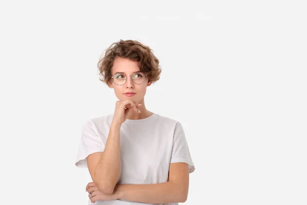 白い背景の上にある右上隅のコピースペースを見ている白いシャツと眼鏡を着た思慮深い若い女性 思考の概念 — ストック写真