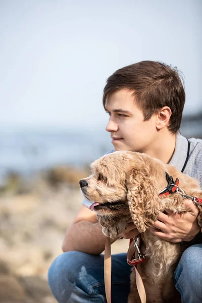 Молодой Человек Обнимает Собаку Берегу Моря Мужчина Ласкающий Послушную Собаку — стоковое фото