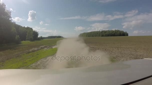 Polvo detrás del coche. Vista trasera desde el coche en una carretera de campo en los campos . — Vídeo de stock