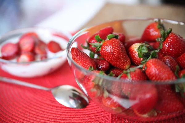Mogna röda jordgubbar i en transparent tallrik — Stockfoto