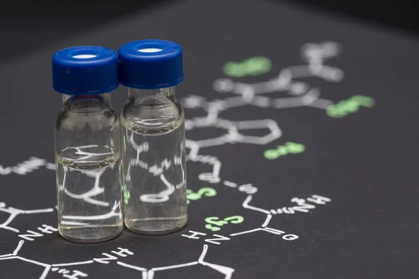 Close-up blauwe cap monster flesjes op papier met de chemische formule van — Stockfoto
